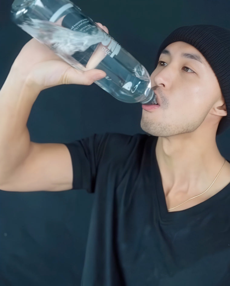 Un homme qui boit une bouteille d'eau